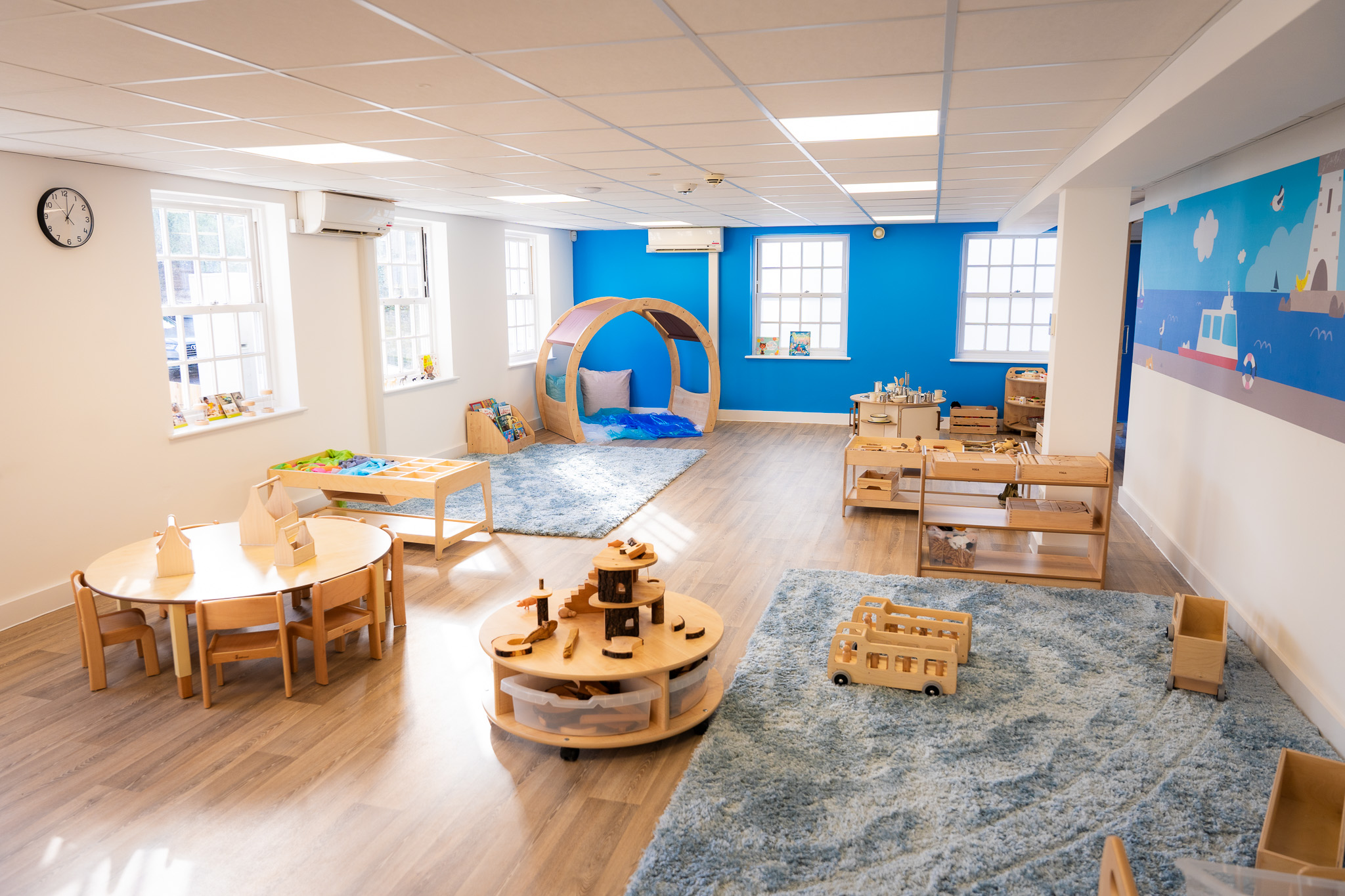 nursery room with wooden tables, chairs and toys