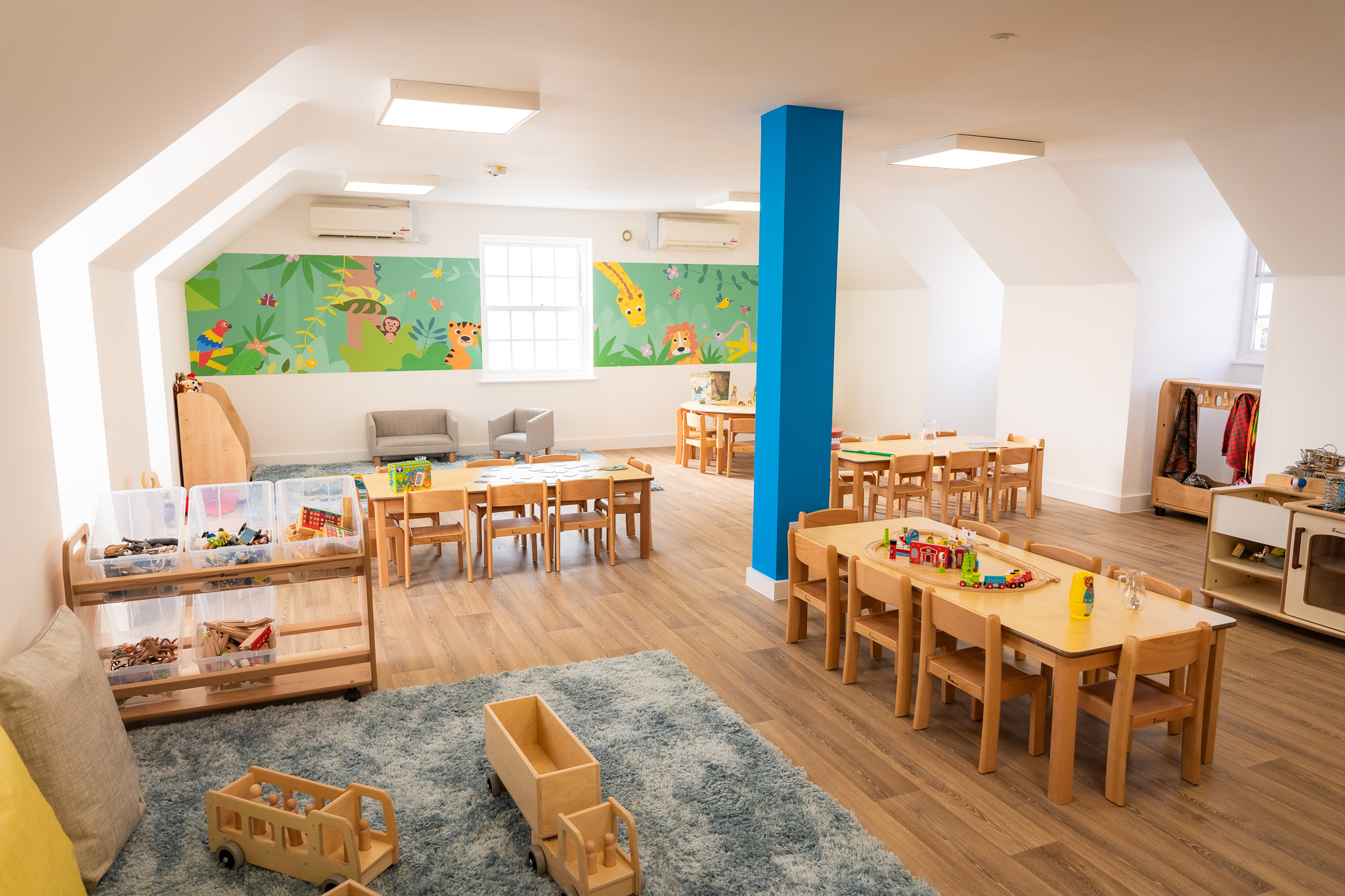 nursery room with wooden tables, chairs and toys